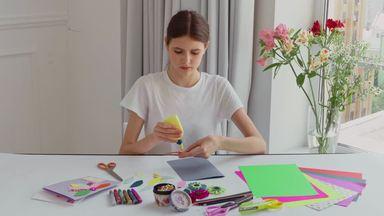 a woman who sticks petals with a bond and makes a card by hand