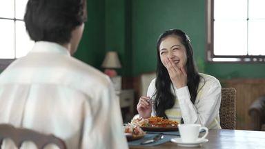 Joyful woman laughing while eating