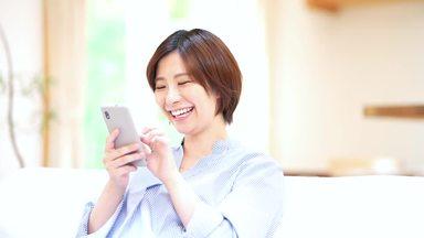 自宅でスマホ検索を楽しむ若い女性