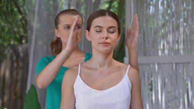 a woman who receives a beauty treatment like qigong while standing