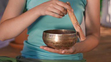 a woman holding a bowl and tracing it with a stick