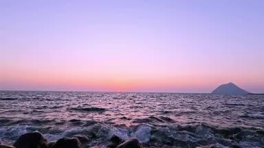 八丈島の横間海岸から見える波打ち際と夕日