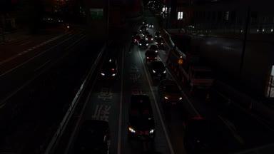 夜の渋谷区で車が走っている道