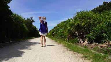 沖縄の美しい道を走る女性