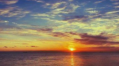 幻想的な夕焼けの空と海に沈む太陽