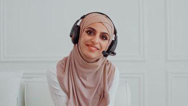 a woman wearing a headset and looking at the camera