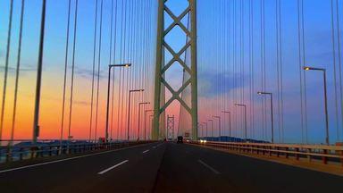 朝焼けの赤い海峡大橋を車で渡るシーン