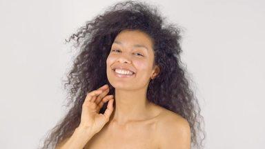 Curly haired woman brushing her hair