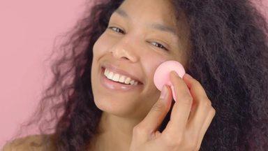 Woman with curly hair applying blush
