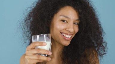 Curly haired woman drinking milk