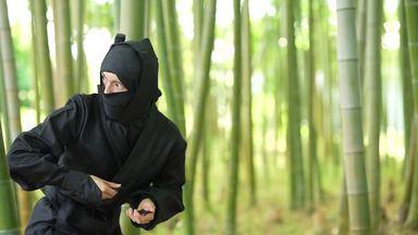 a ninja who throws a shuriken while watching the surroundings with a bamboo bush
