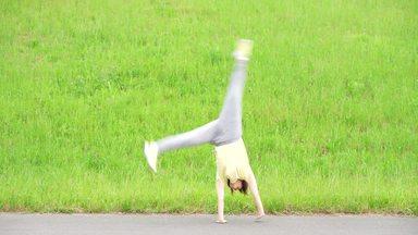 a woman looking at the camera with a cartwheel
