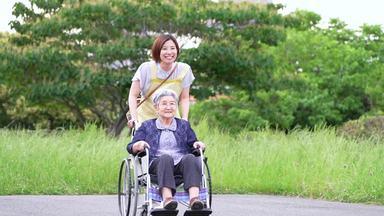 車椅子で移動する高齢女性