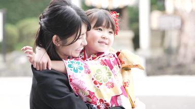 a mother hugging her daughter in a sunny kimono