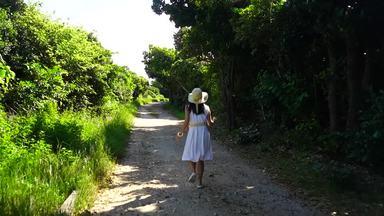 沖縄の美しい道を走る女性