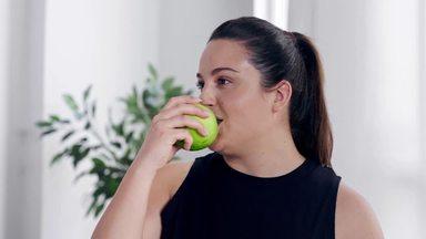 chubby woman biting a green apple