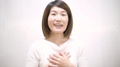 胸に手を当てて安心する日本人女性