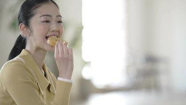 バウムクーヘンを食べて笑顔の女性