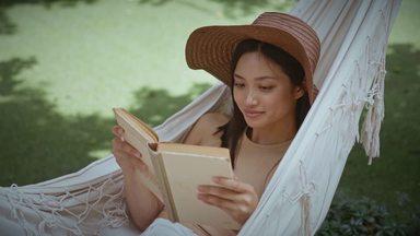 a woman reading a book in a hammock