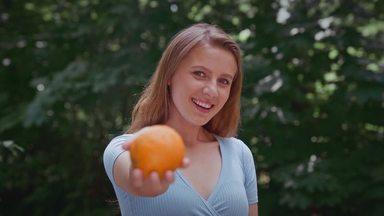 オレンジを持っている女性