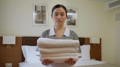 清潔なタオルをもつハウスキーパーの女性