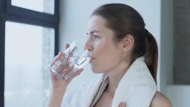 汗を拭き水を飲む女性