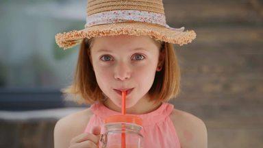 girl drinking juice looking at the camera