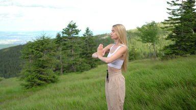 草原で立って瞑想する女性