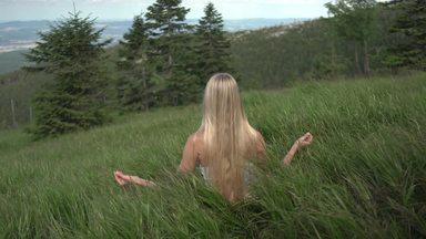 草原でヨガの瞑想をする女性