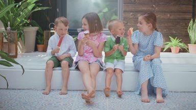 children sitting and eating ice cream happily