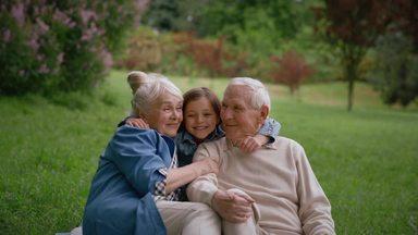 a girl running and hugging her grandparents