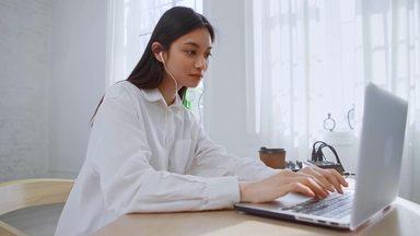 a woman wearing earphones and working on a computer