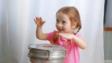 Girl playing drums in the living room