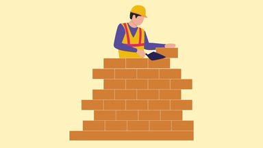 a male worker who piles up bricks to make a fence