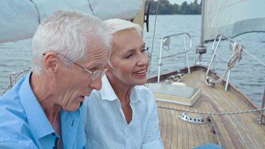 elderly couple talking on a yacht