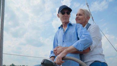 elderly couple driving a yacht