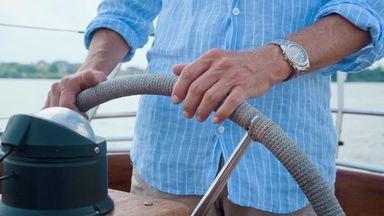 hands of an elderly man operating a yacht